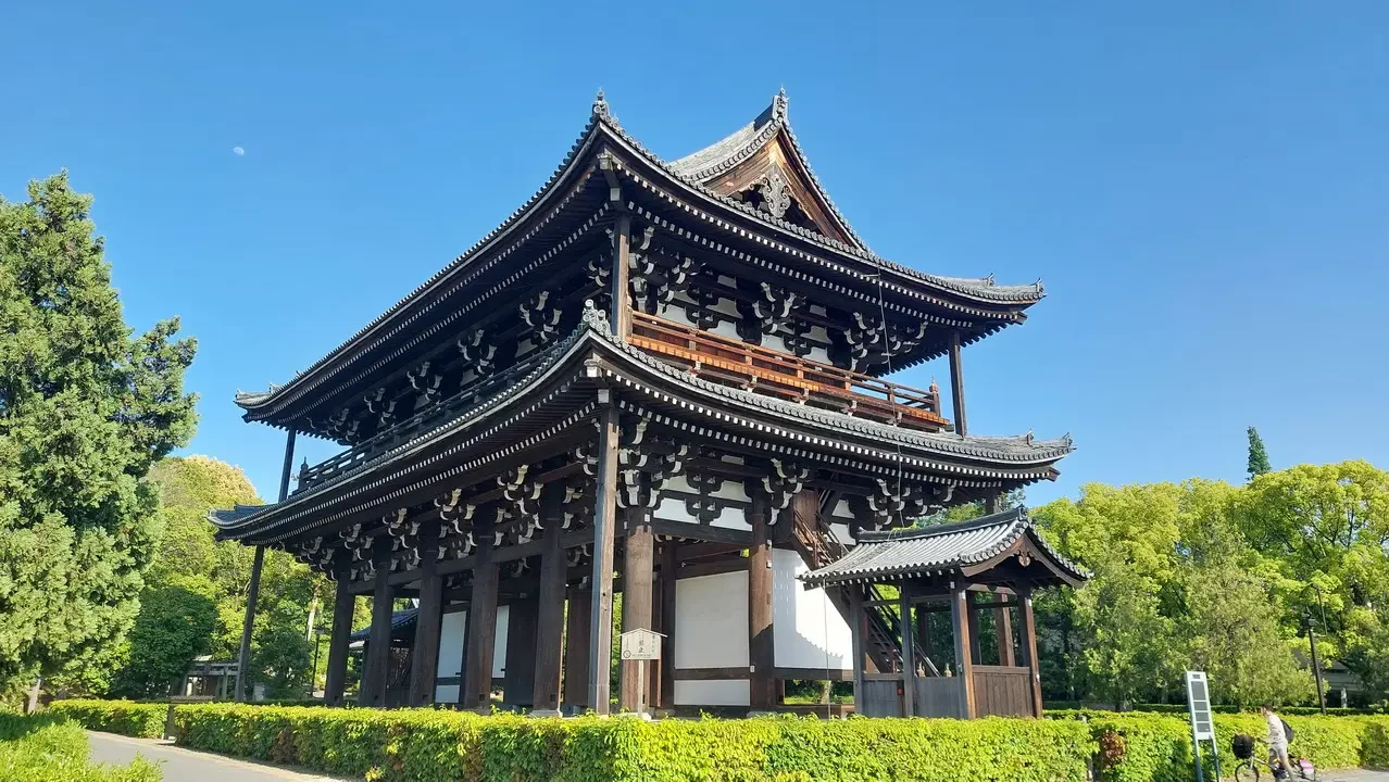 Vista del tempio Tofuku-ji a Kyoto con un cielo azzurro e alberi verdi.