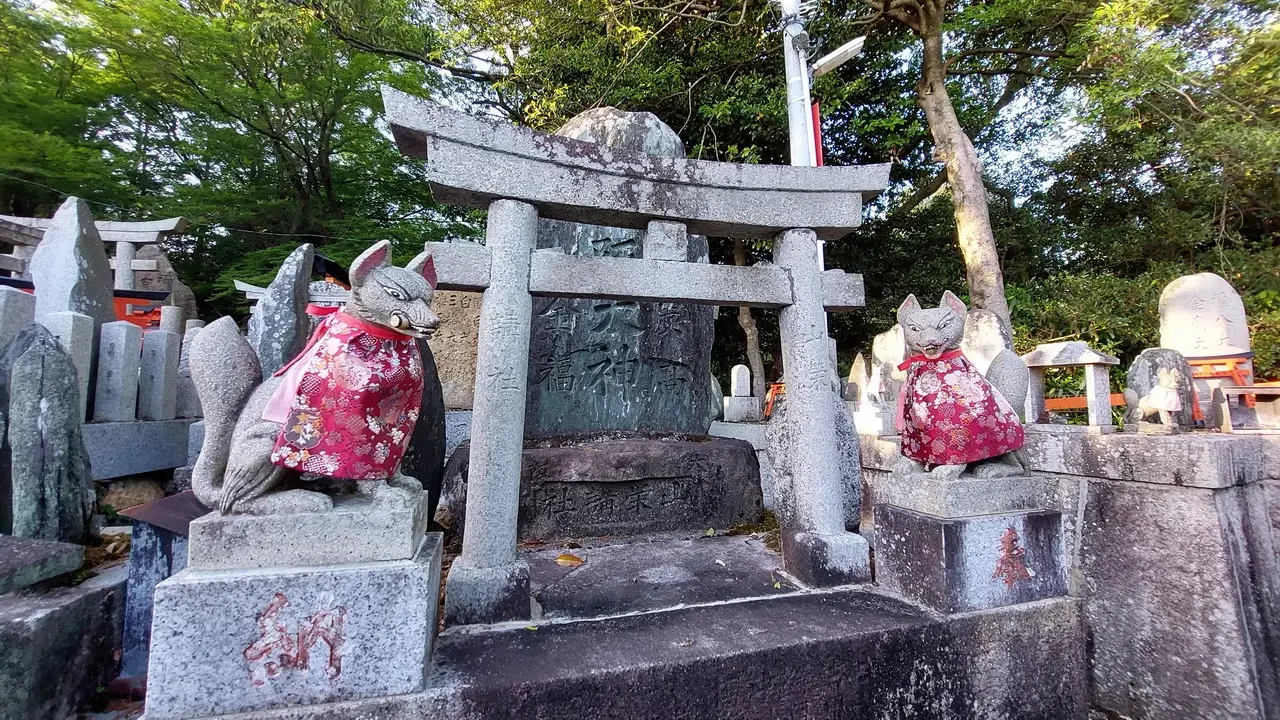 Portali torii rossi e pietra in un santuario giapponese.