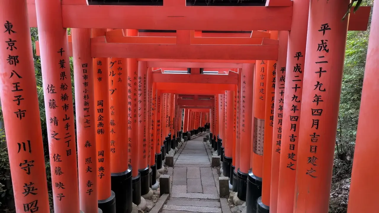Il santuario di Fushimi Inari con i suoi portali rossi e le torii che si estendono in lontananza.