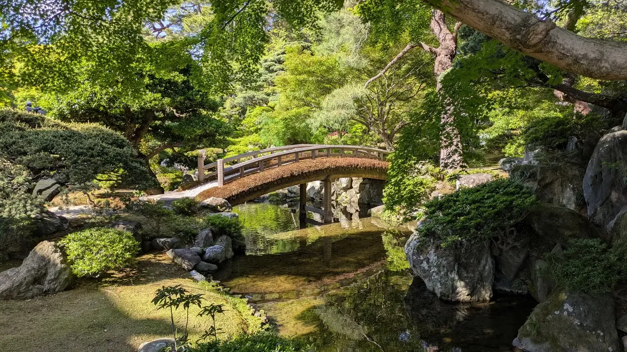 Il Palazzo Imperiale di Kyoto è visibile attraverso un ponte in un giardino giapponese.