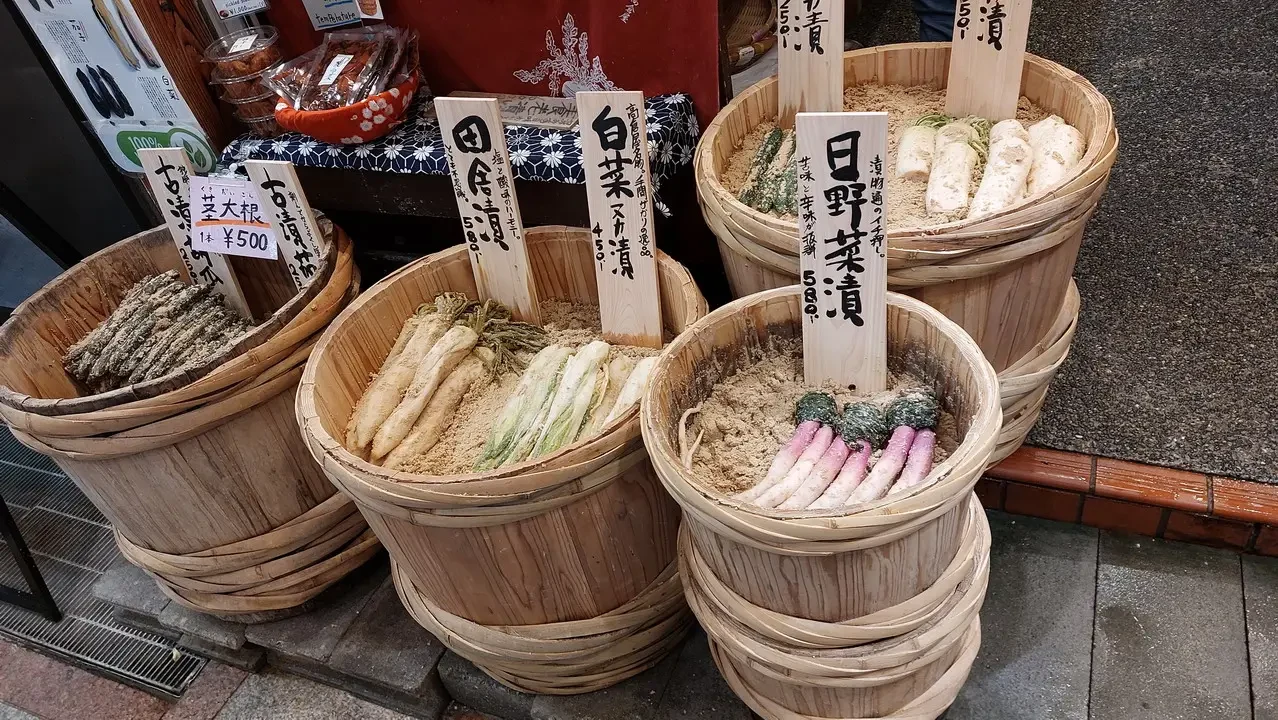 Vasi di vimini pieni di verdure fresche sono esposti in un mercato giapponese.