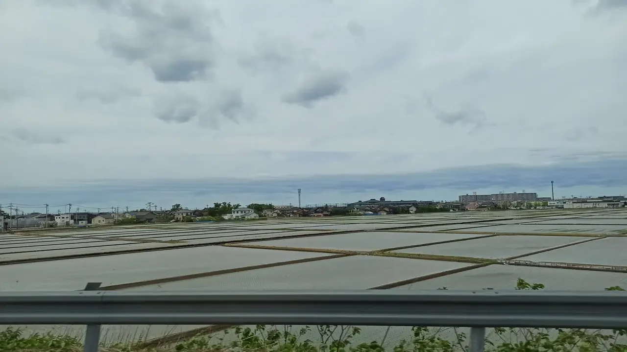 Un paesaggio agricolo piatto sotto un cielo nuvoloso in Giappone.