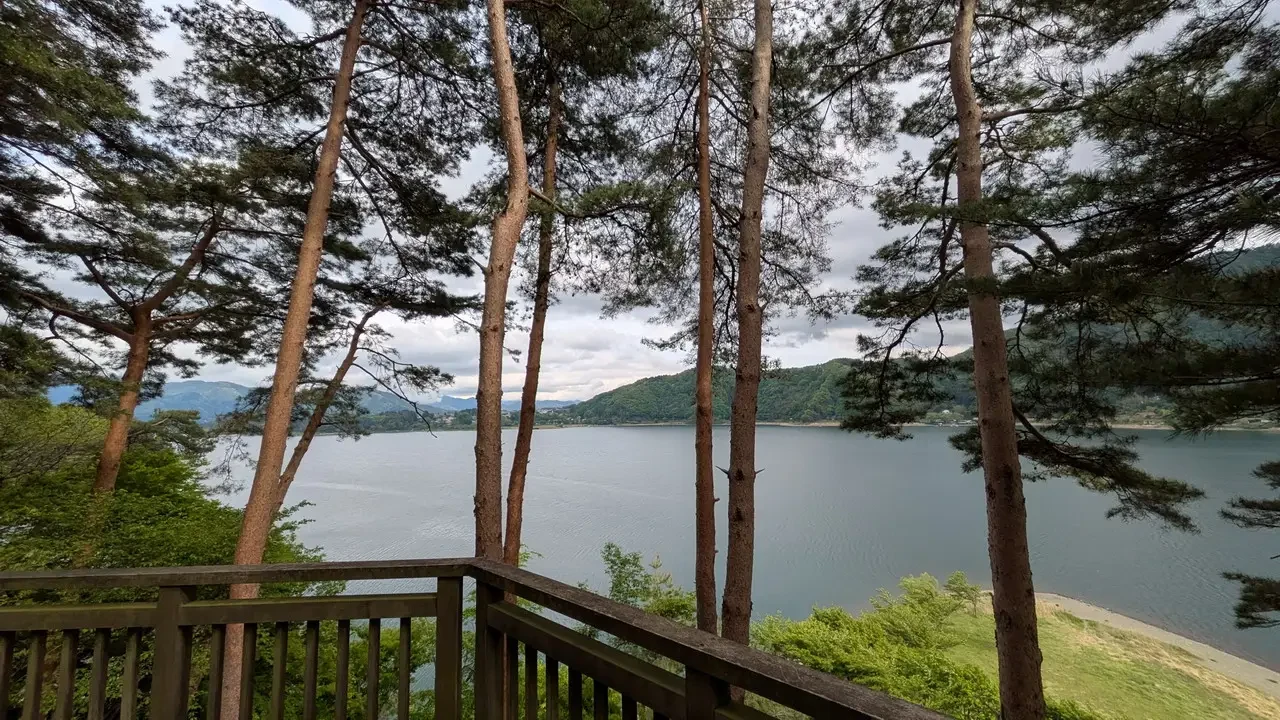 Vista panoramica di un lago circondato da foreste e montagne in Giappone.