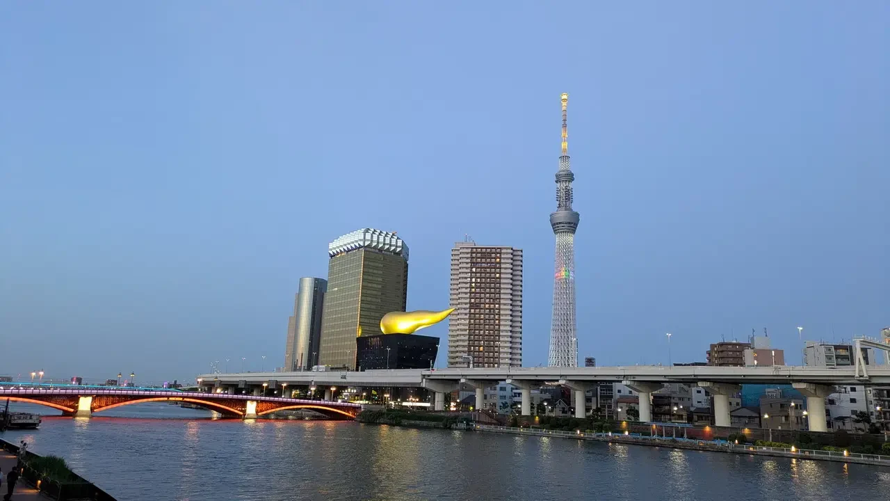 Panorama notturno della Tokyo con la Tokyo Skytree visibile sul fiume.