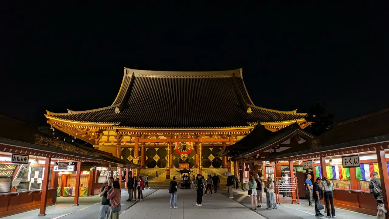 Veduta notturna del tempio Senso-ji a Tokyo con architettura tradizionale illuminata.