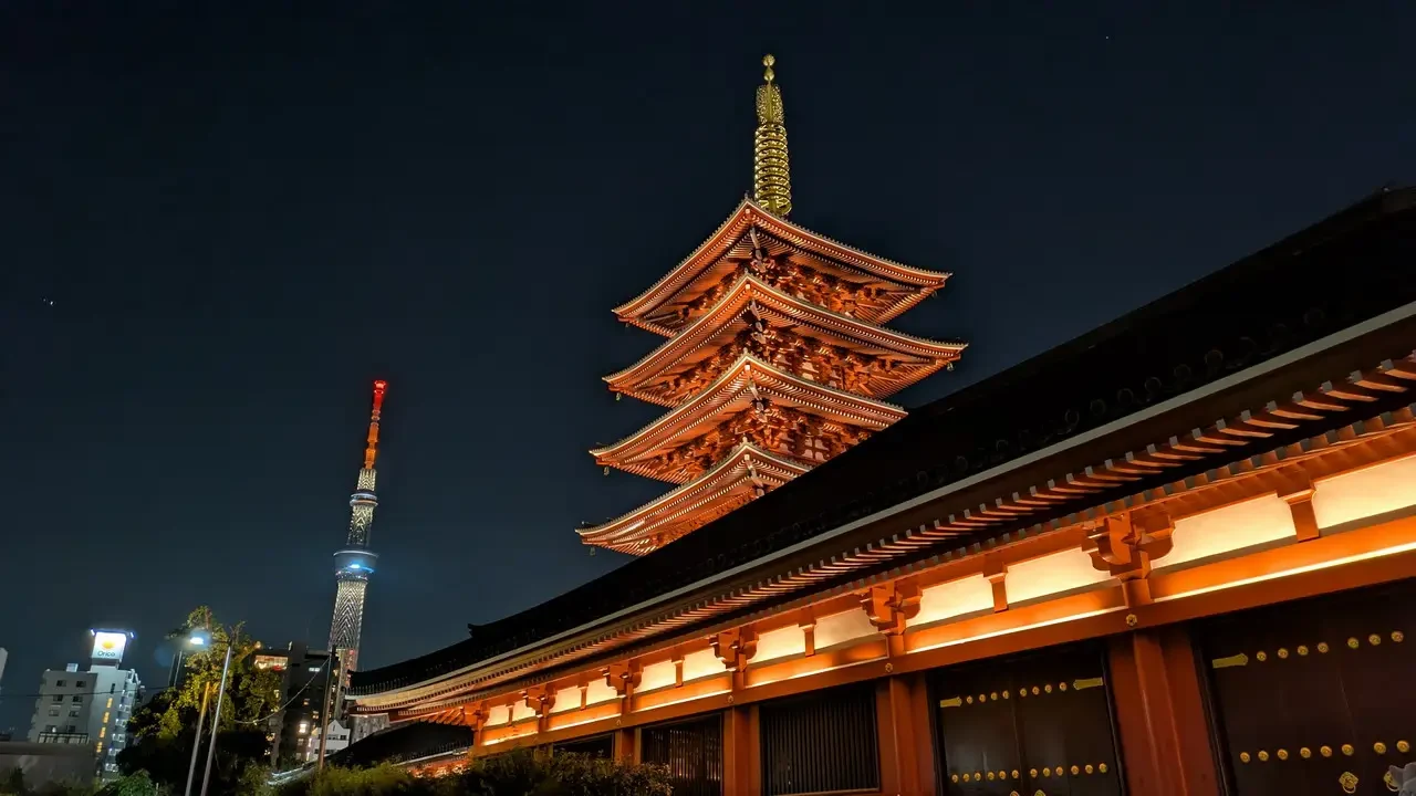 Vista notturna del tempio Senso-ji di Tokyo con il suo tetto ornato illuminato.