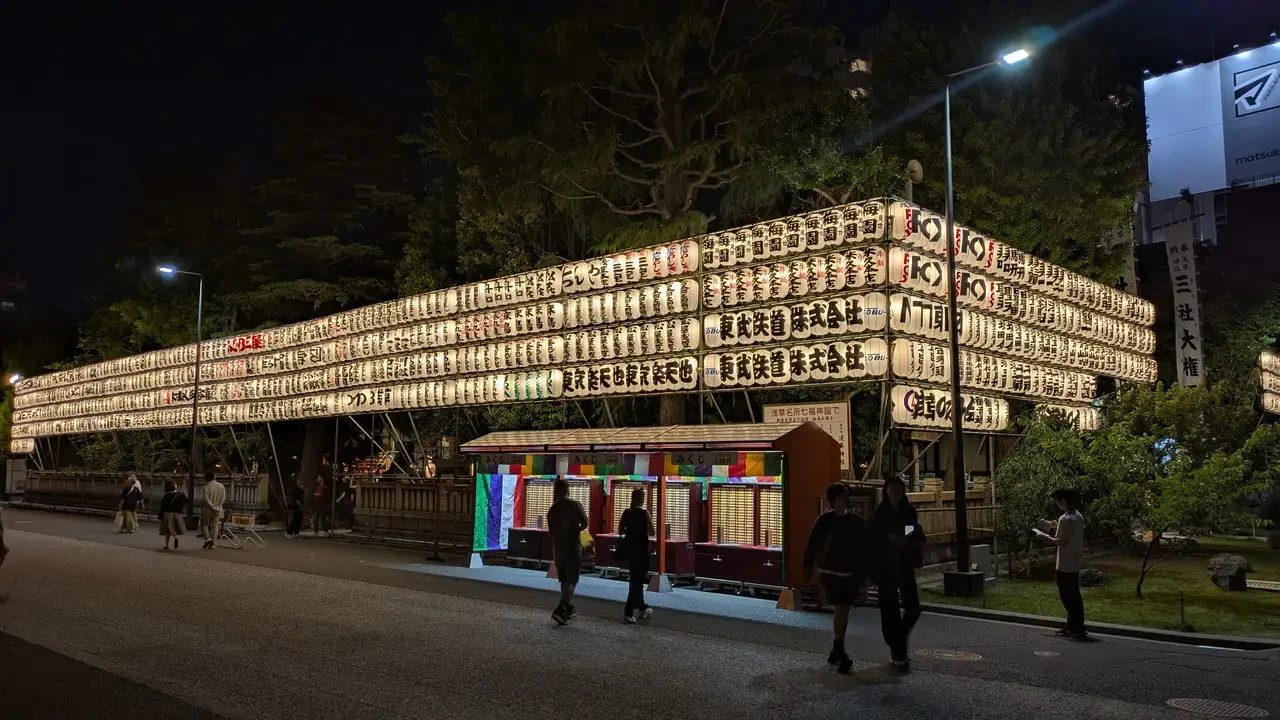 La strada serale davanti al Senso-ji a Tokyo è adornata da luminose insegne tradizionali.