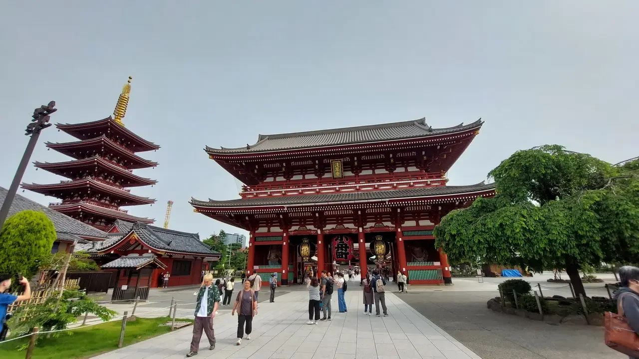 Vista della porta principale del tempio Senso-ji a Tokyo con edifici tradizionali circostanti.