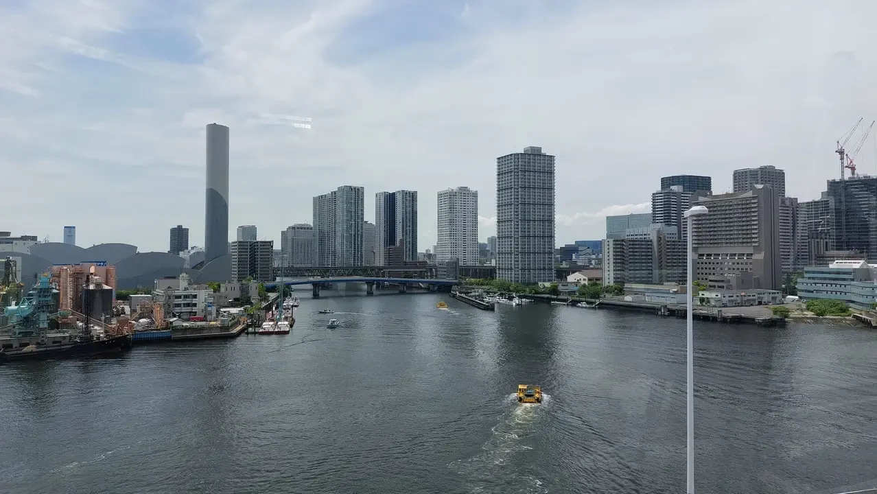 Vista panoramica della città di Tokyo con edifici e un fiume in primo piano.