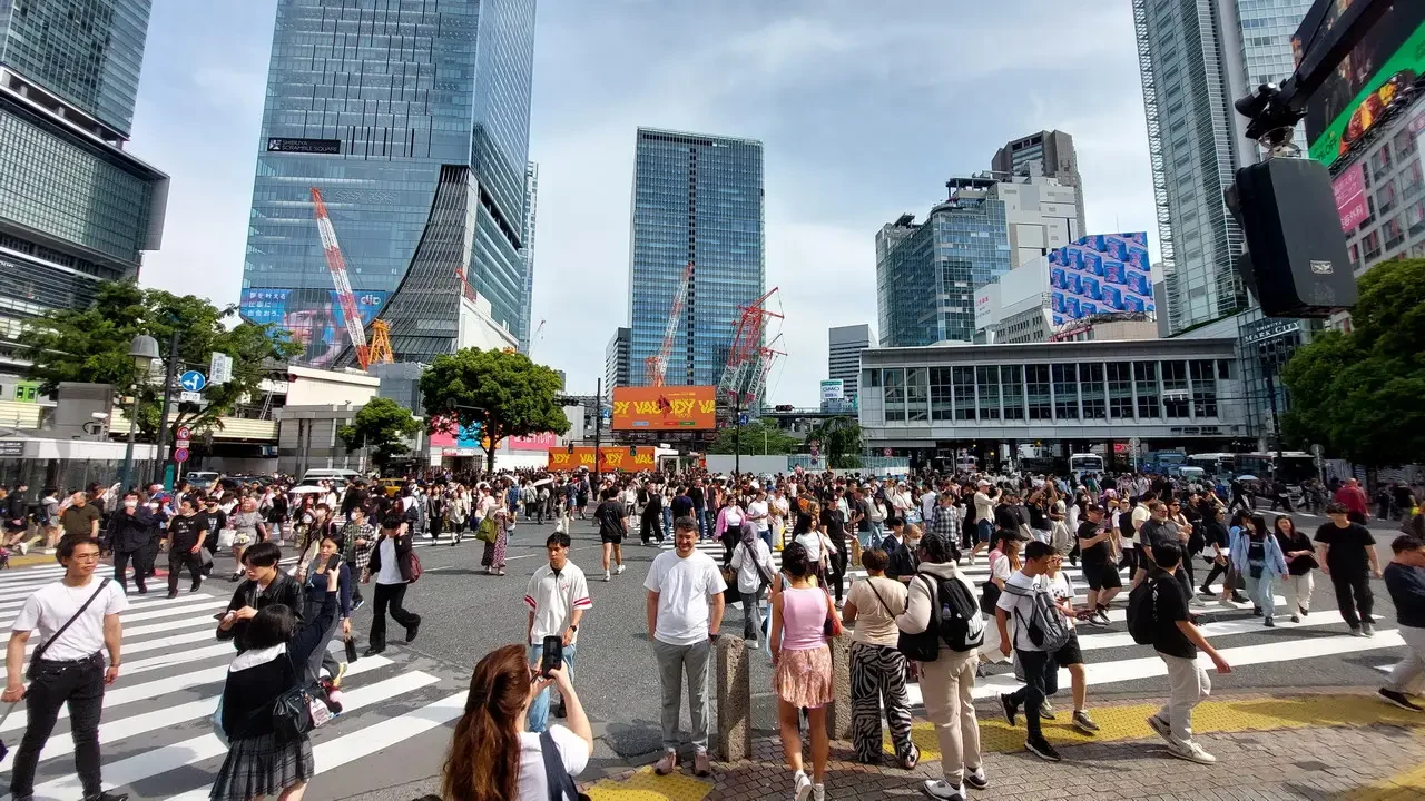 Una folla di persone attraversa il famoso incrocio di Shibuya a Tokyo.