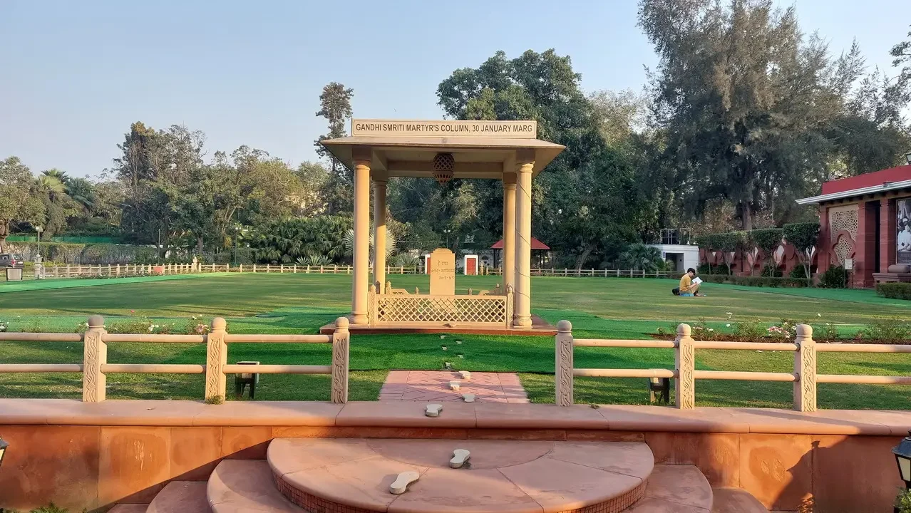 Giardino verde con una struttura in pietra e un monumento in India.