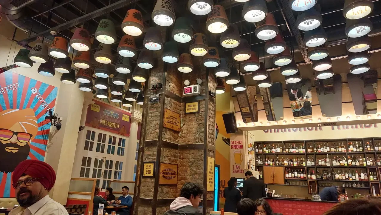 Interno caldo e decorato di un ristorante indiano con illuminazione rustica.