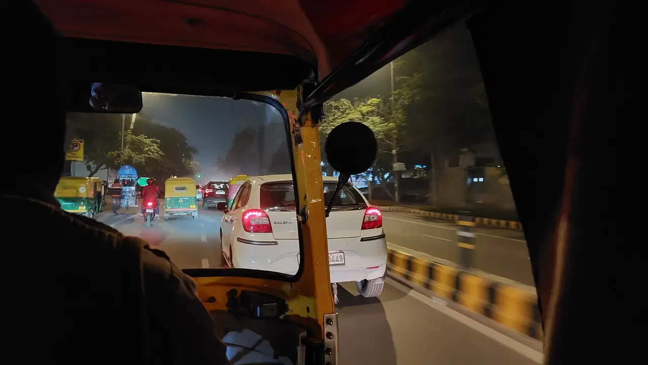 A journey in a tuk-tuk through an Indian street at dusk.