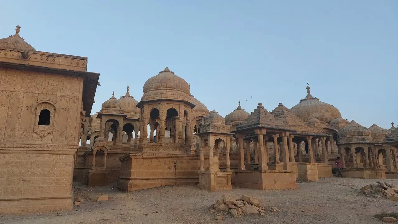 Un complesso di edifici in pietra con cupole in un paesaggio arido.
