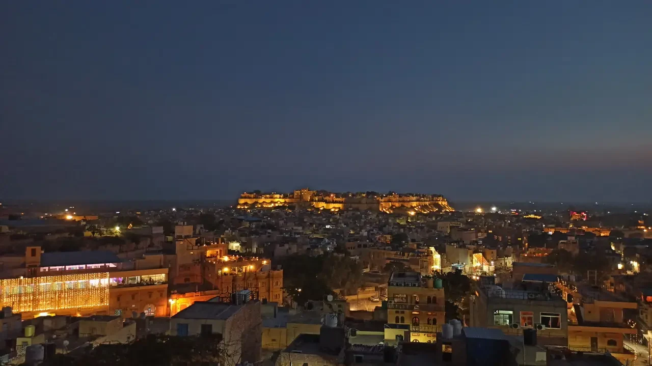 Una vista notturna della città di Jaisalmer in India con edifici illuminati.