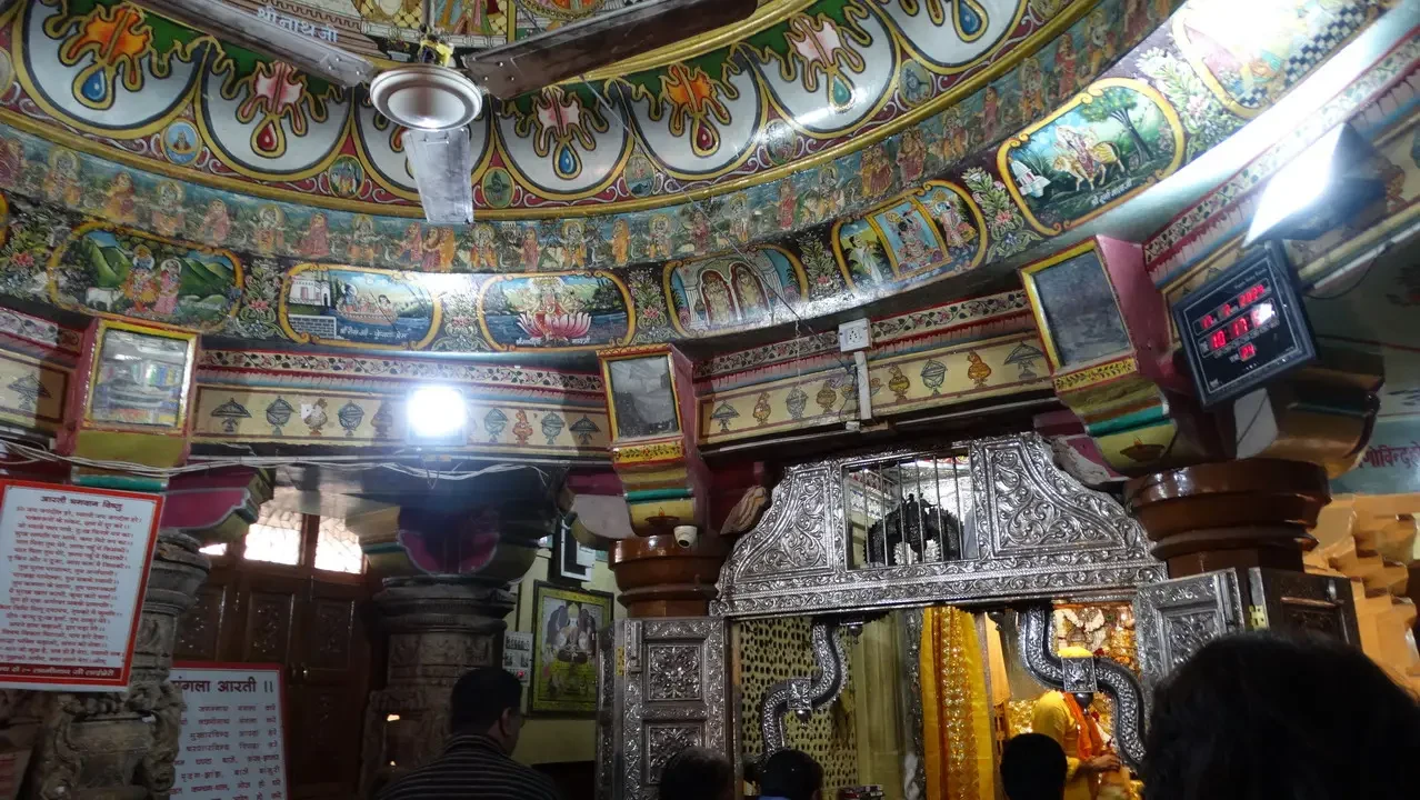 Interno decorato di un tempio indiano con soffitto elaborato e dettagli dorati.