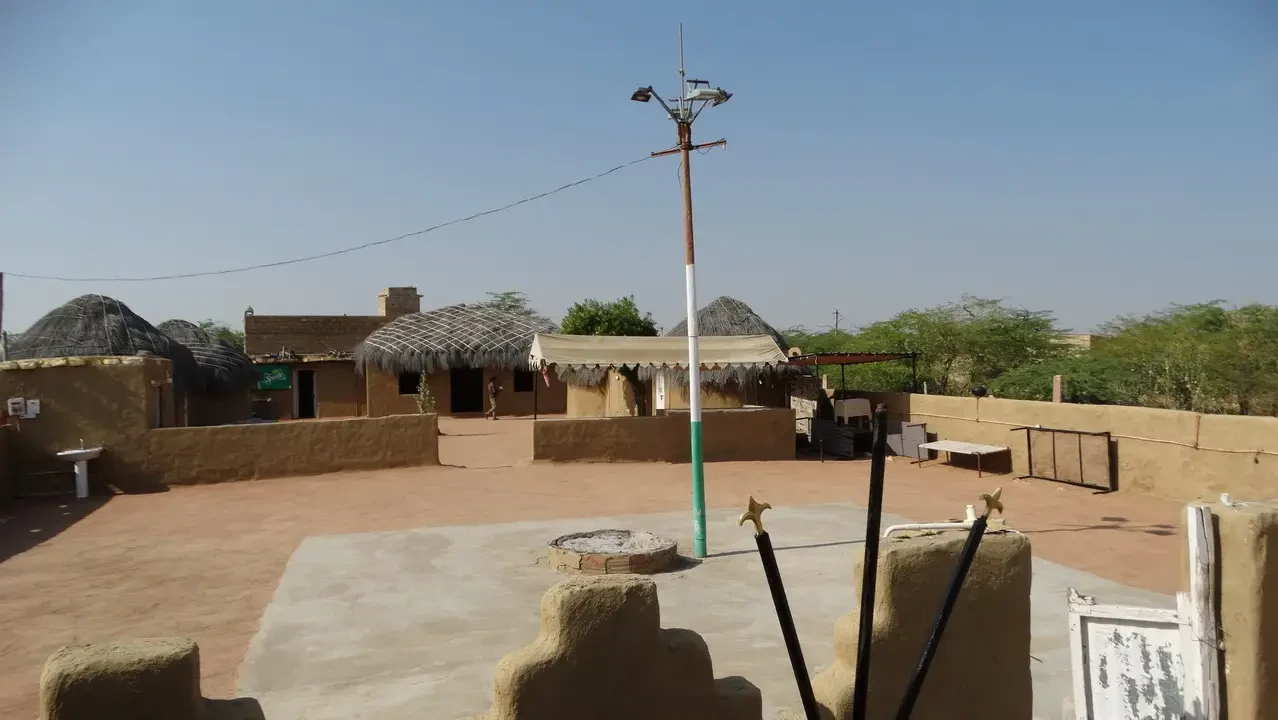 Struttura di alloggi in stile tradizionale nel deserto indiano con un'area aperta.