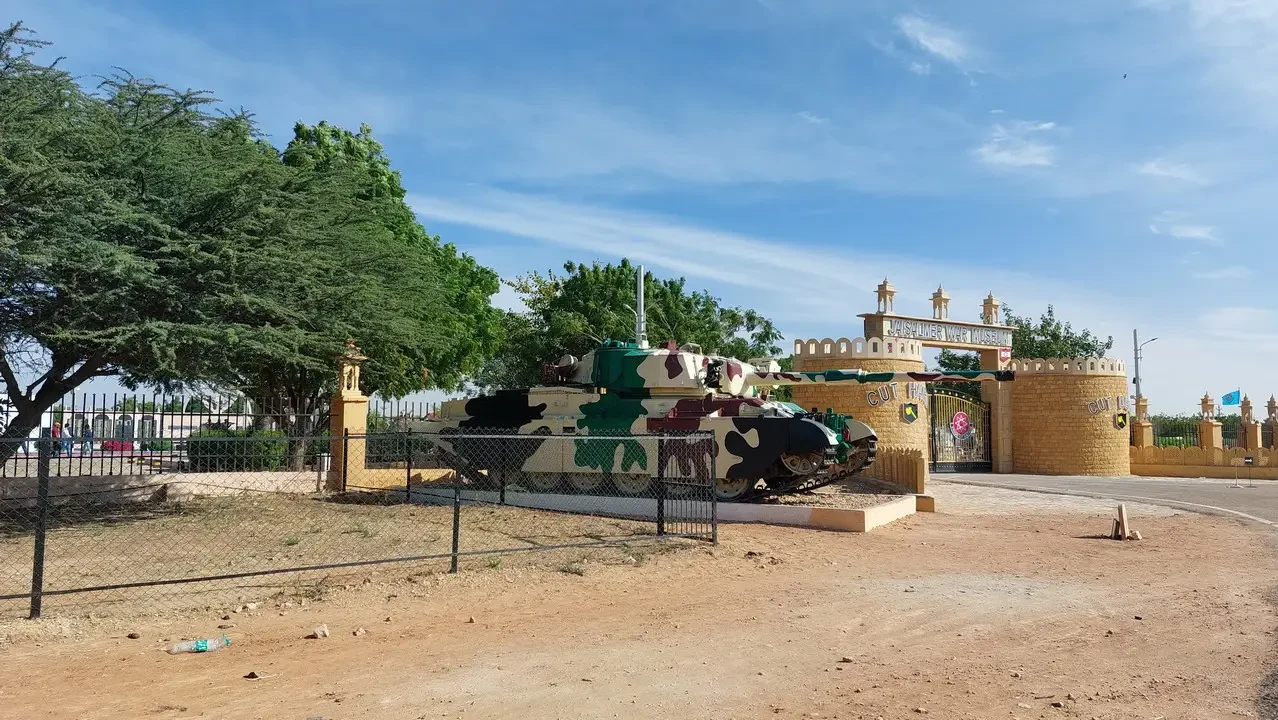 Una mostra militare è esposta in un ambiente desertico con mura di mattoni gialli.