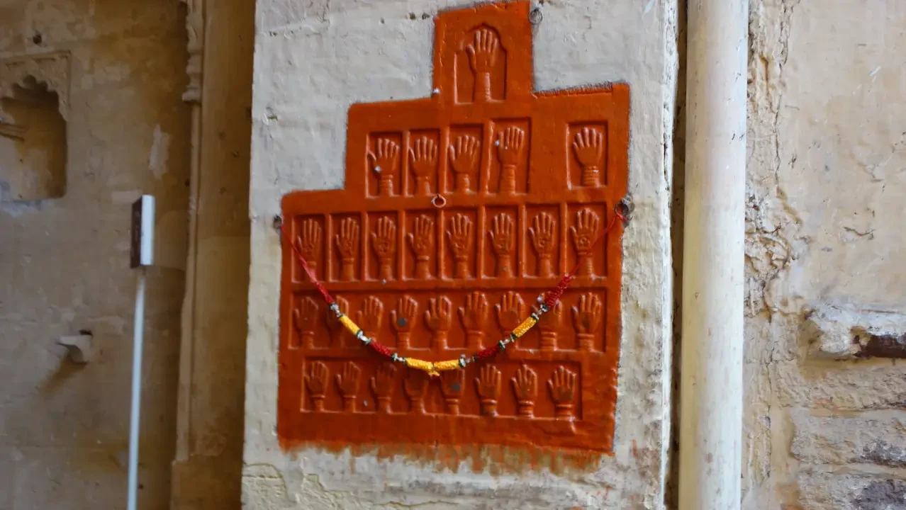 Mural depicting a pattern of open hands on a wall in Jodhpur, India.