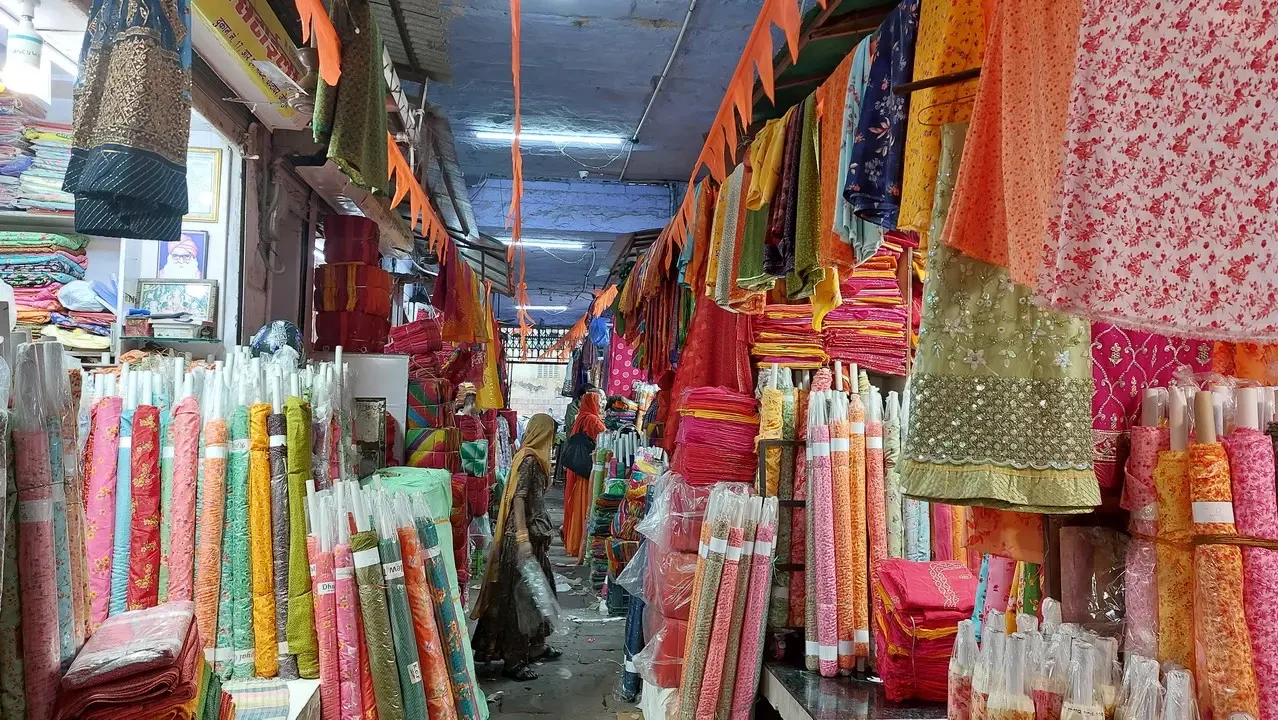 Una galleria di tessuti colorati è esposta in un mercato indiano.