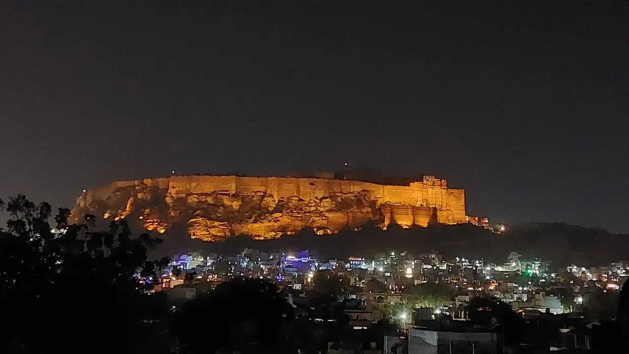 Il forte di Mehrangarh a un'imponente struttura rocciosa illuminata di notte.