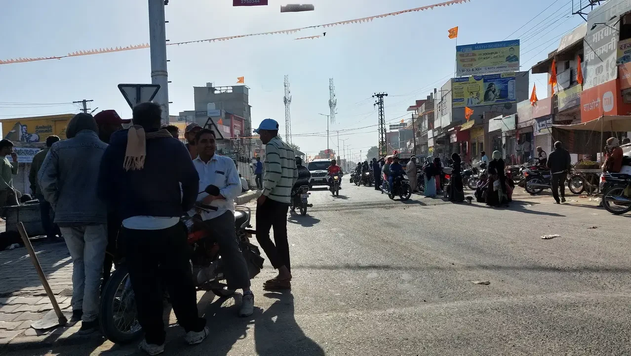 Lavoratori senza impiego in una strada trafficata in India.