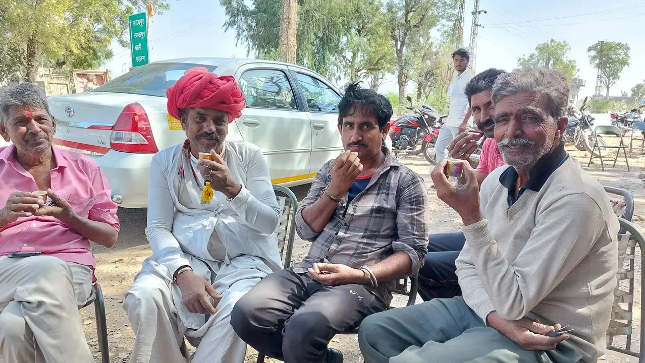 Uomini siedono all'aperto godendosi una pausa in India.