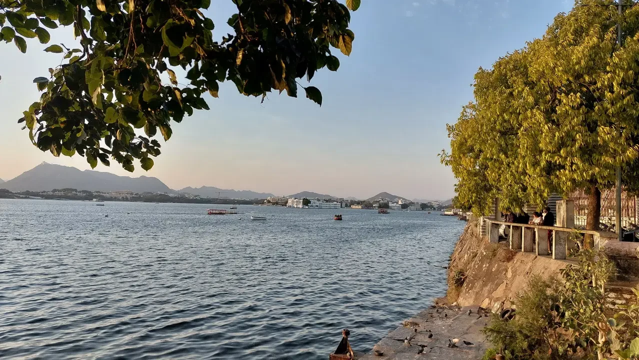 Vista panoramica di un lago indiano con alberi in primo piano.