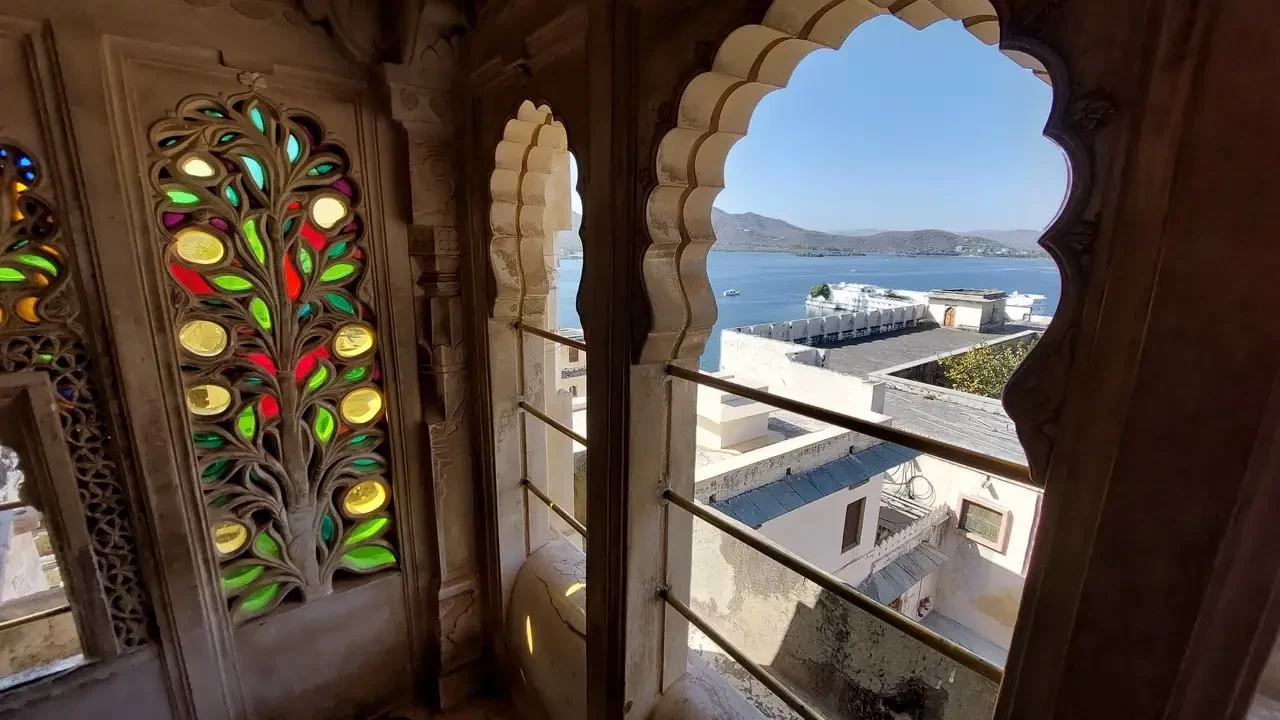 Finestre ornate con motivi a griglia incorniciano una vista panoramica sulla città e sull'acqua.