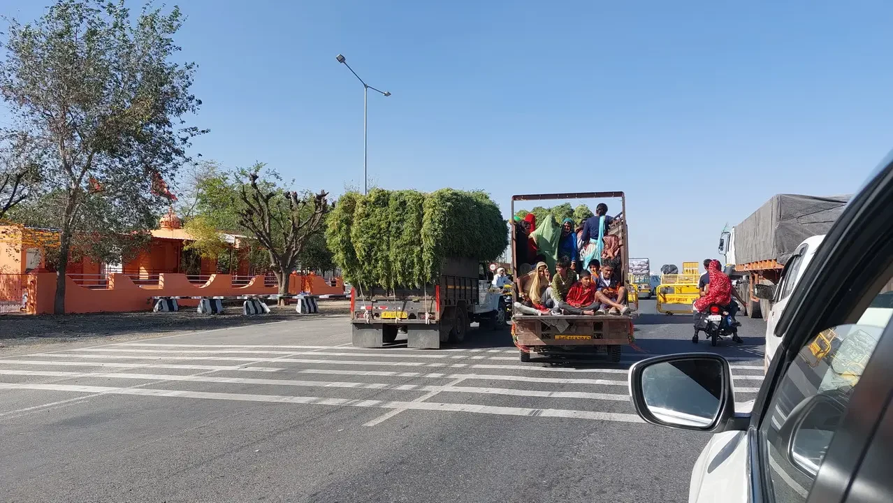 Vita cittadina ad Ajmer con veicoli in movimento.