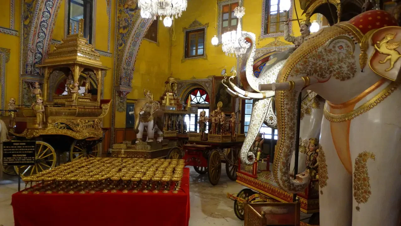 Interno di un tempio indiano decorato con elaborati oggetti dorati e una grande decorazione animale.