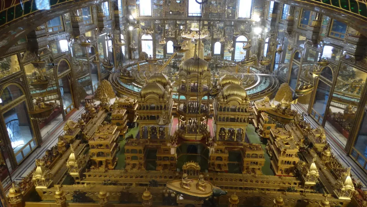 Interno dorato e sontuoso di un edificio religioso indiano.