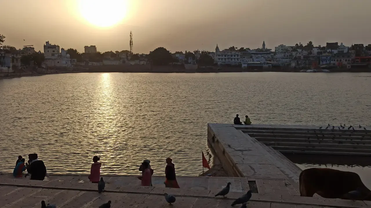 Tramonto sopra la città di Pushkar in India riflesso sull'acqua.
