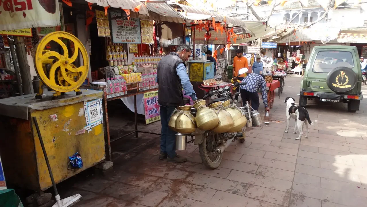Mercato all'aperto a Pushkar con bancarelle di merci e persone che passeggiano.