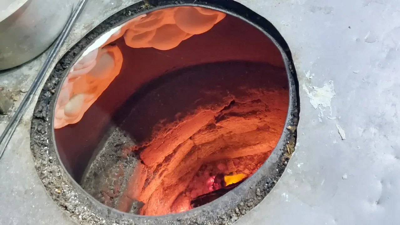 Vista interna di un forno o una struttura in terracotta con colori rossi e arancioni.