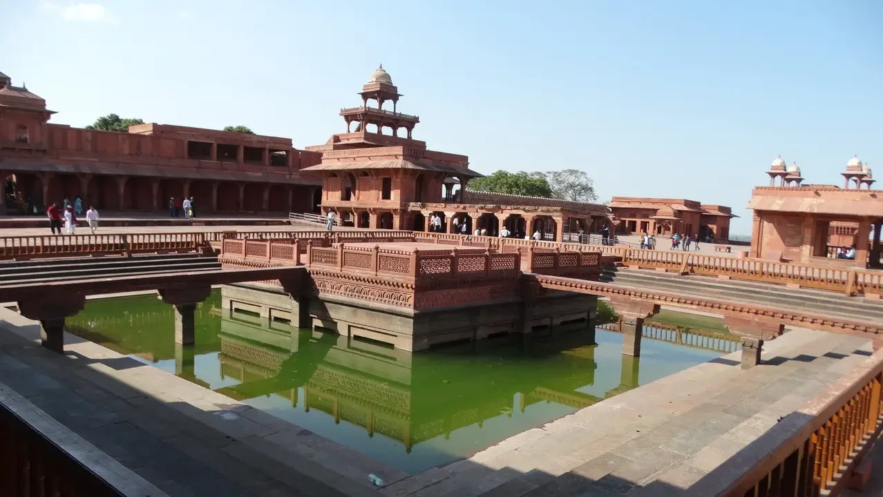 Architettura in mattoni di Fatehpur Sikri con un grande specchio d'acqua al centro.