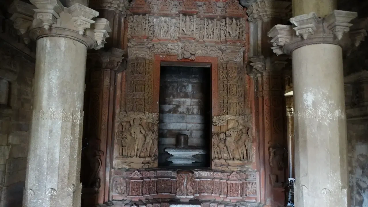 Dettaglio delle colonne scolpite di un tempio indiano con rilievi intricati.