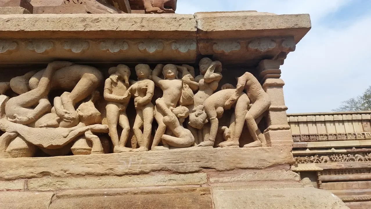 Rilievi scolpiti mostrano figure mitologiche su un basamento antico indiano.
