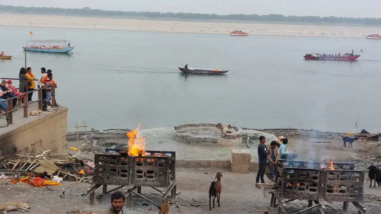 Barche e fuoco galleggiano sul fiume durante un'attività all'aperto in India.