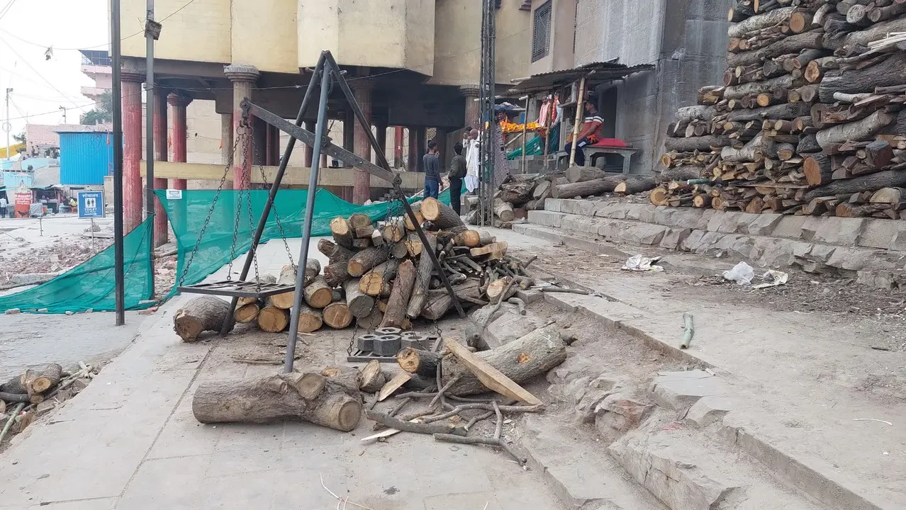 Pila di legna da ardere e tronchi lungo la riva del fiume in India.