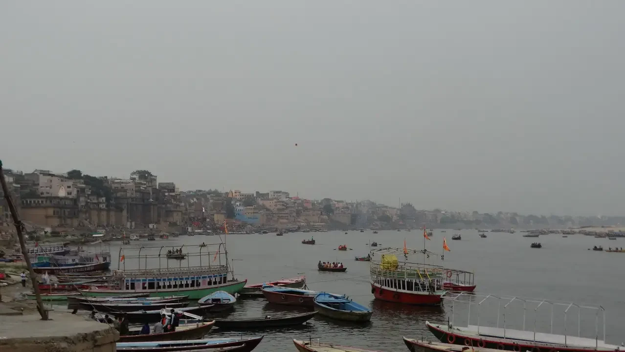 Vista del ghat di Varanasi con imbarcazioni sul fiume.