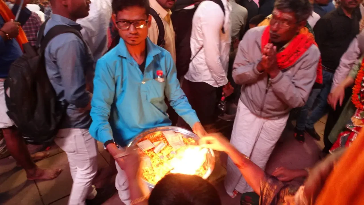 Un gruppo di persone partecipa a un aarti del fiume Gange in India con una lampada di fuoco.