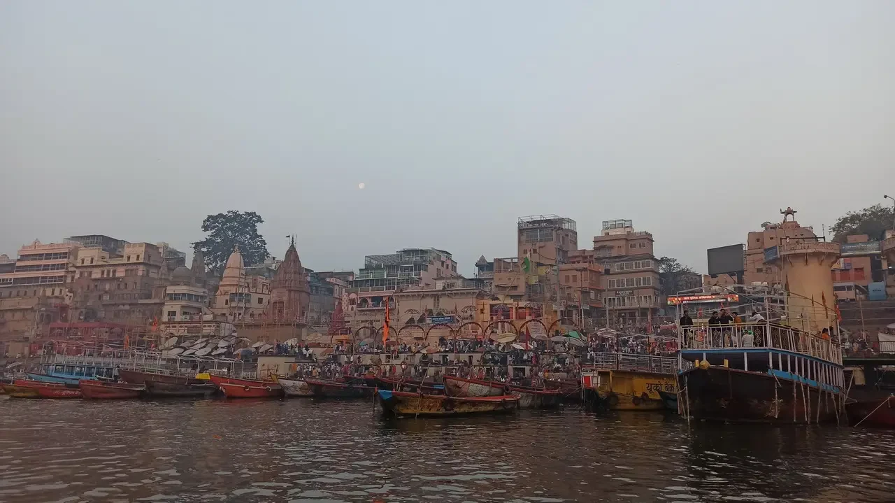 Un viaggio in barca lungo il fiume con edifici storici in India.