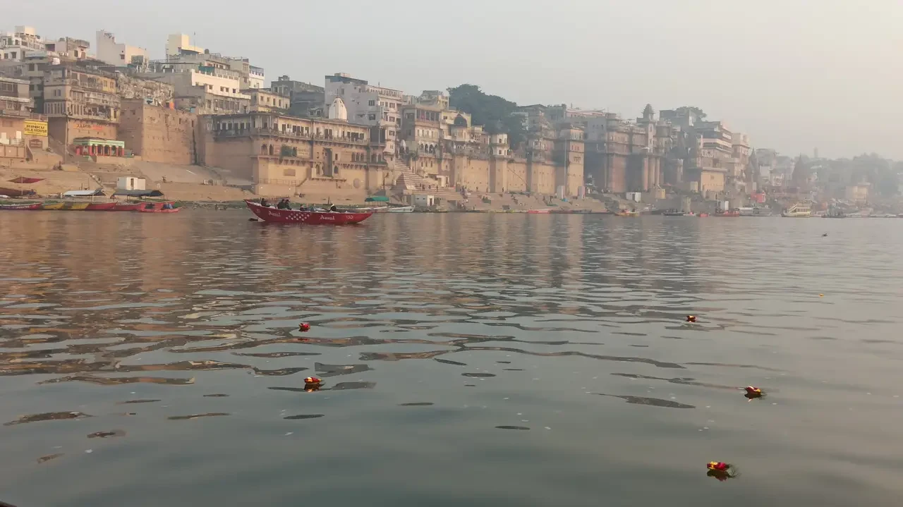 Un viaggio in barca lungo il fiume con edifici storici in India.