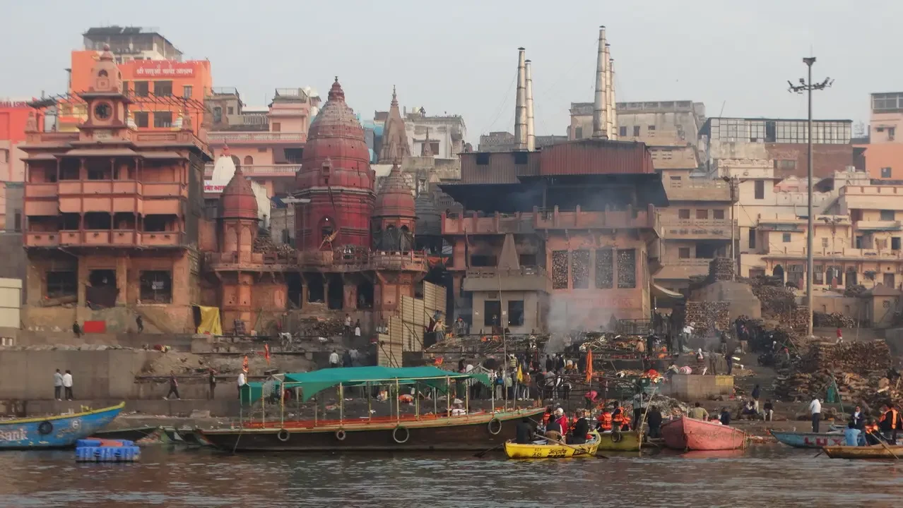 Una gita in barca sul fiume a Varanasi con edifici storici in primo piano.