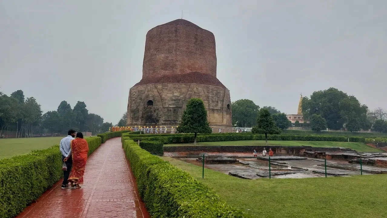 Una stupa antica in mattoni domina un parco verde con sentieri curvi.