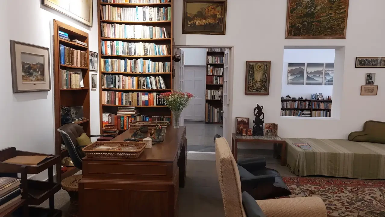 Interno di un museo in India con scaffali pieni di libri e opere d'arte.