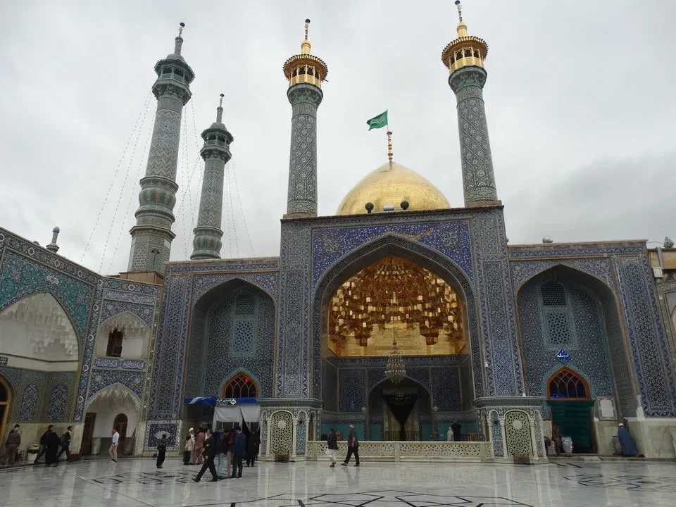Vista esterna della moschea di Qom in Iran con minareti e cupole dorate.