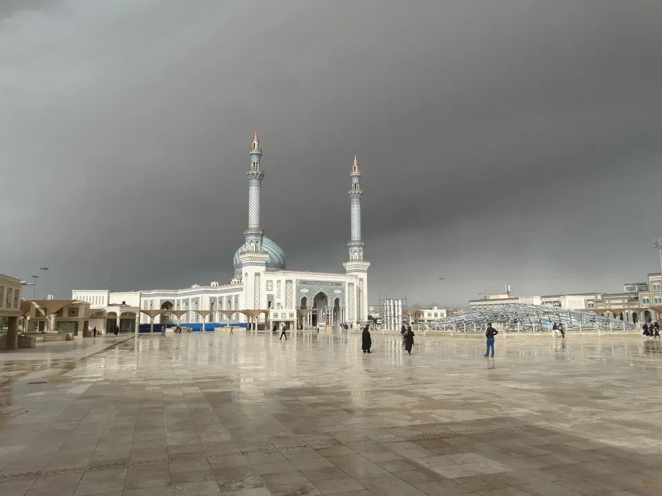 Vista ampia della moschea di Imam Hasan a Qom con i suoi minareti sotto un cielo coperto.