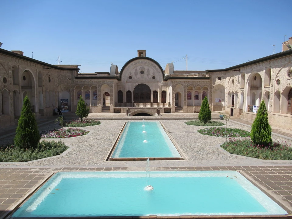 Cortile interno con arcate e fontane in un complesso architettonico iraniano.